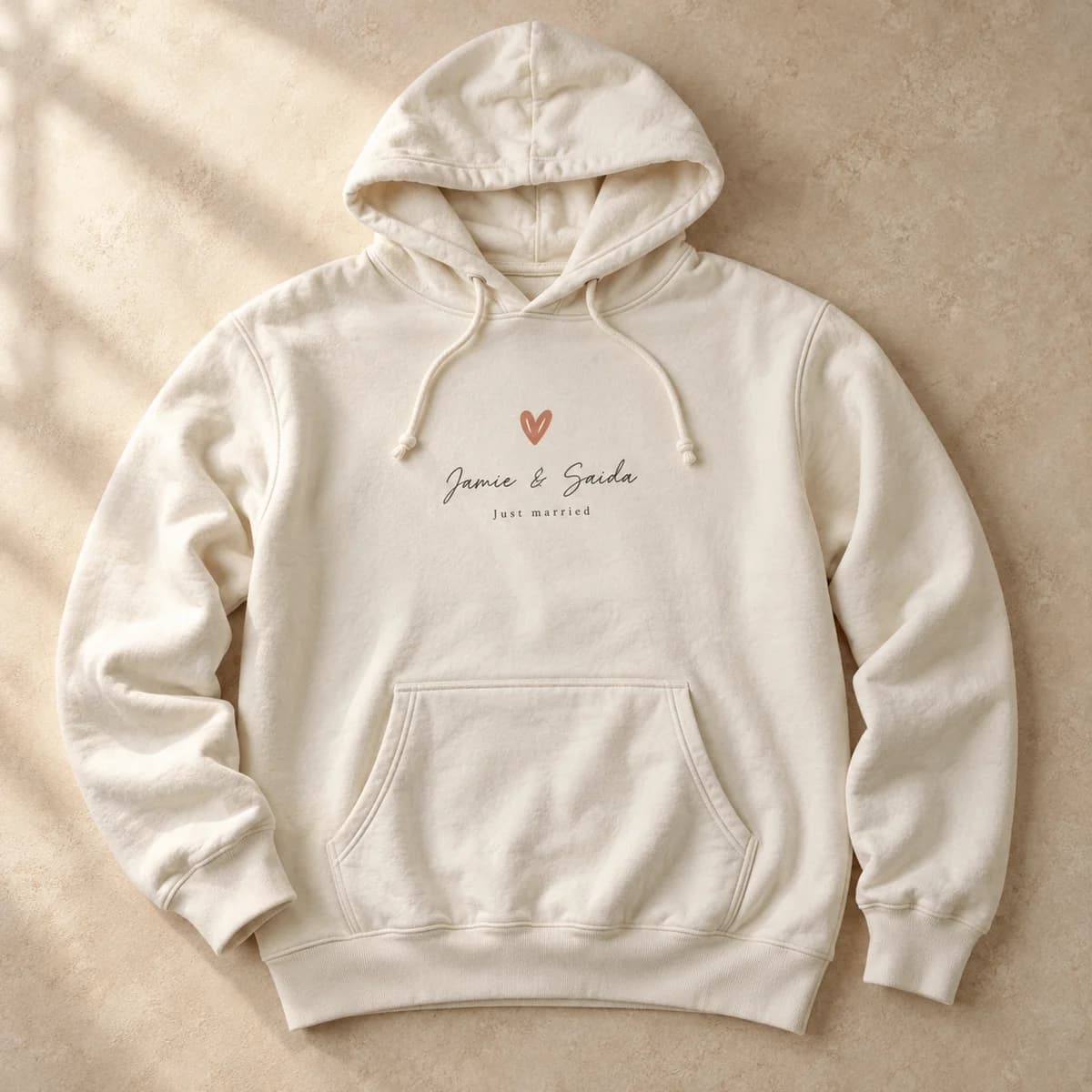 Cream hoodie printed with a small heart and a couple's names